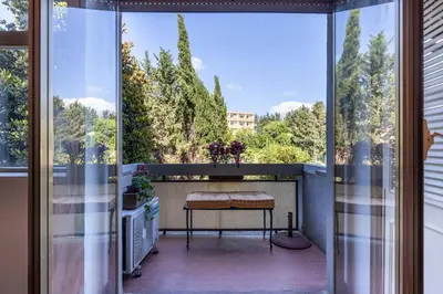 a balcony with a table and a view of trees at Plaza Cheery Suite in Rome