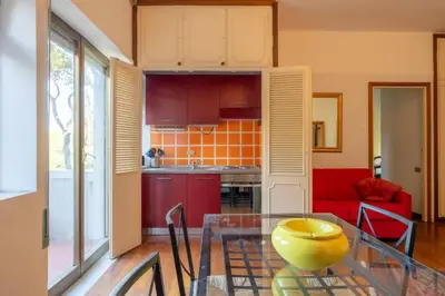 a kitchen with a glass table and a red couch at Plaza Cheery Suite in Rome