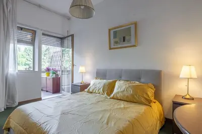 a bedroom with a bed and two lamps and a window at Plaza Cheery Suite in Rome