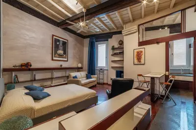 a bedroom with two beds and a desk and a couch at GuestHost - Piazza Navona Petite House in Rome