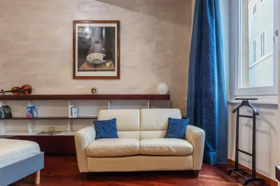 a living room with a white couch and blue pillows at GuestHost - Piazza Navona Petite House in Rome