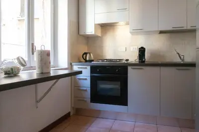 a kitchen with white cabinets and a black oven at EasyTopStay - Cosy Flat near Castel S Angelo in Rome