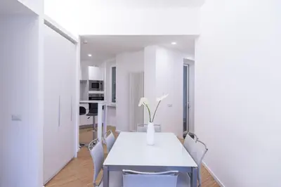 a white dining room with a white table and chairs at La casa di Livia in Rome