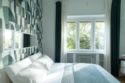 a bedroom with a bed and two windows at La casa di Livia in Rome