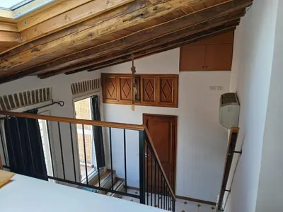 a staircase in a house with wooden ceilings at Attico con terrazza Santa Cecilia in Rome
