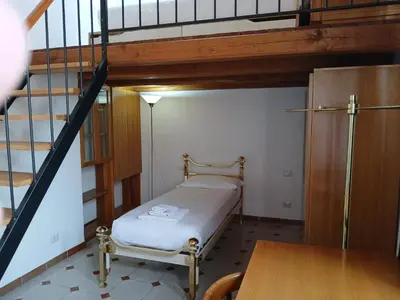 a small room with a bed and a staircase at Attico con terrazza Santa Cecilia in Rome