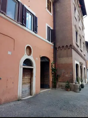 an orange building with two garage doors on a street at Attico con terrazza Santa Cecilia in Rome