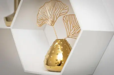 a small gold vase with a plant in it at SolferinoNove in Rome