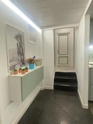 a hallway with white walls and a green door at Loft Torlonia in Rome