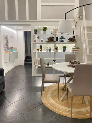 a dining room with a white table and chairs at Loft Torlonia in Rome