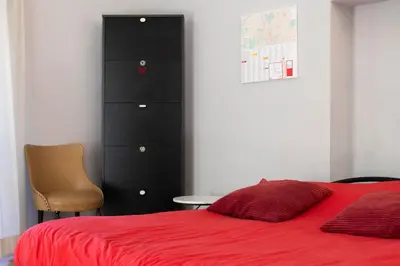 a bedroom with a red bed and a black dresser at Obiettivo Roma in Rome