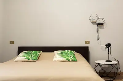 a bed with two green pillows and a lamp at Obiettivo Roma in Rome