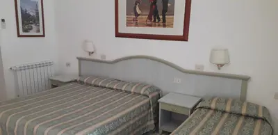 a bedroom with two beds and a picture on the wall at Gioia Guest House in Rome