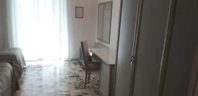 a room with a desk with a mirror and a refrigerator at Gioia Guest House in Rome