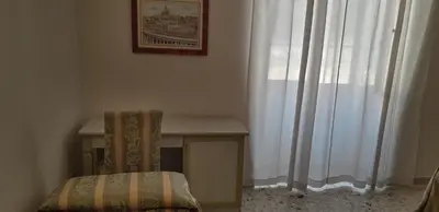 a chair sitting next to a desk and a window at Gioia Guest House in Rome