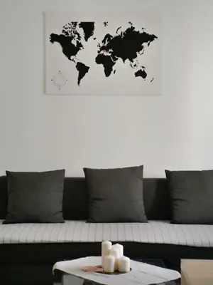 a living room with a couch with a world map on the wall at Modern 1 Bedroom near metro in Rome