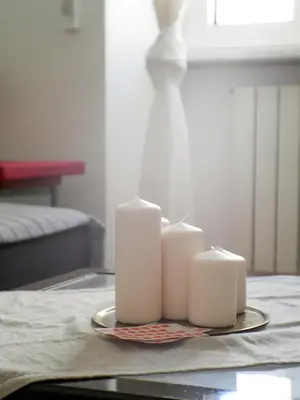 two white candles on a plate on a table at Modern 1 Bedroom near metro in Rome