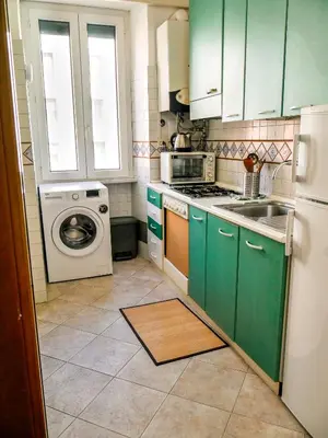 a kitchen with green cabinets and a washing machine at Modern 1 Bedroom near metro in Rome