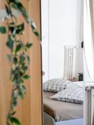 a bedroom with a bed and a door with a plant at Modern 1 Bedroom near metro in Rome