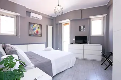 a bedroom with a bed and a tv and windows at Casa Mapi in Rome
