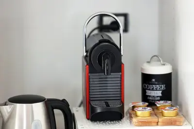 a coffee maker sitting on top of a counter with cupcakes at Casa Mapi in Rome