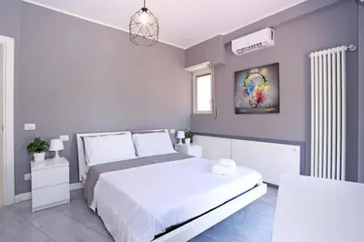 a bedroom with a white bed and a painting on the wall at Casa Mapi in Rome