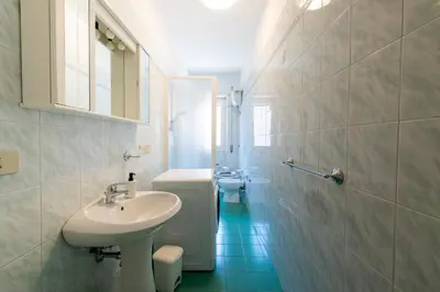 a white bathroom with a sink and a toilet at Casa Tripolitania in Rome