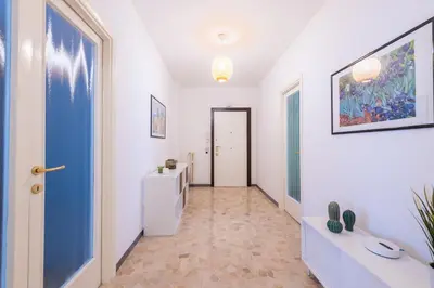 a hallway with white walls and a blue door at Casa Tripolitania in Rome