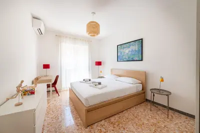 a bedroom with a bed and a desk and a chair at Casa Tripolitania in Rome