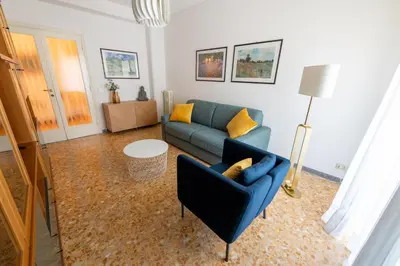 a living room with a blue couch and yellow pillows at Casa Tripolitania in Rome