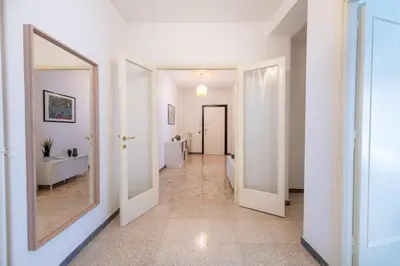 a hallway with white walls and a large mirror at Casa Tripolitania in Rome