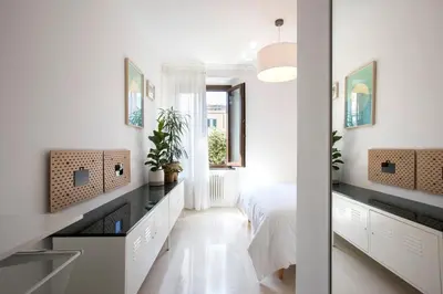a white bedroom with a bed and a window at Giardino al 9 in Rome