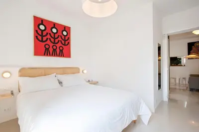 a bedroom with a white bed and a red painting on the wall at Giardino al 9 in Rome