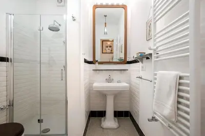 a white bathroom with a sink and a mirror at Giardino al 9 in Rome