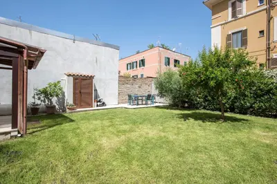 a backyard with a grass yard and a building at Giardino al 9 in Rome