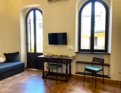 a living room with a desk and two windows at Terraces under the Moon in Rome