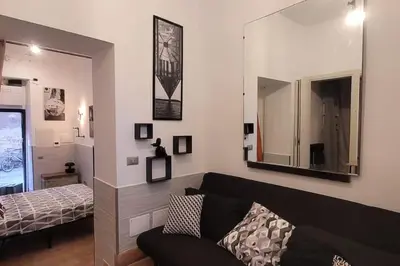 a living room with a couch and a mirror at Trastevere Home Gallery in Rome