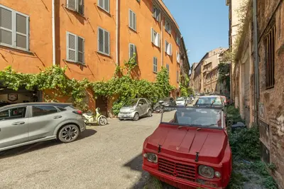 a red car parked on the side of a street at Charming Design Apartment in Monti in Rome