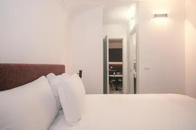 a white bed with white pillows in a bedroom at Youroom Monteverde - Rooms in Rome