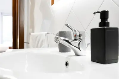 a bathroom sink with a faucet and a soap dispenser at Roma SanPaolo Apartment in Rome