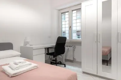 a bedroom with a bed and a desk and a chair at Roma SanPaolo Apartment in Rome
