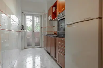 a kitchen with wooden cabinets and a refrigerator at Roma SanPaolo Apartment in Rome