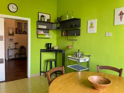 a dining room with a table and a green wall at Quiet in Biancamano - Metro A - San Giovanni - Centro Storico in Rome