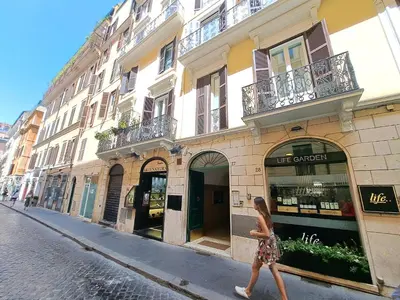 a woman walking down a street in front of a building at Suite della Vite 27 in Rome