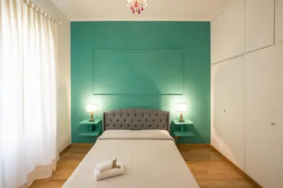 a bedroom with a bed with a blue wall at ROMA your home in trastevere e gianicolo in Rome