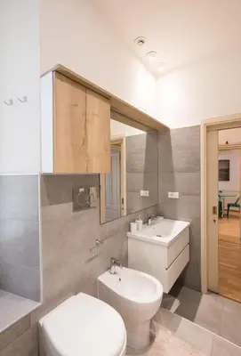 a bathroom with a toilet and a sink and a mirror at ROMA your home in trastevere e gianicolo in Rome