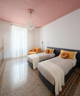 a bedroom with two beds and a chandelier at New apartment with amazing view of S Peter's Dome in Rome