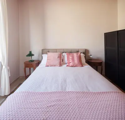 a bedroom with a large bed with pink pillows at New apartment with amazing view of S Peter's Dome in Rome