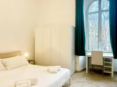 a bedroom with two beds and a desk and a window at DaliTourism - Vatican Apartment 193 in Rome