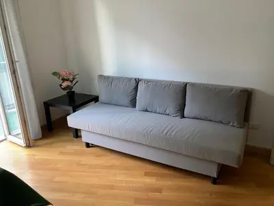a couch sitting in a living room with a table at FAIROME Apartment 2 Pini in Rome